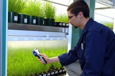 High Resolution Plant Phenomics Centre staff demonstrating imaging equipment within growing cabinets. HRPPC facility, Canberra. Client: Xavier Sirault.